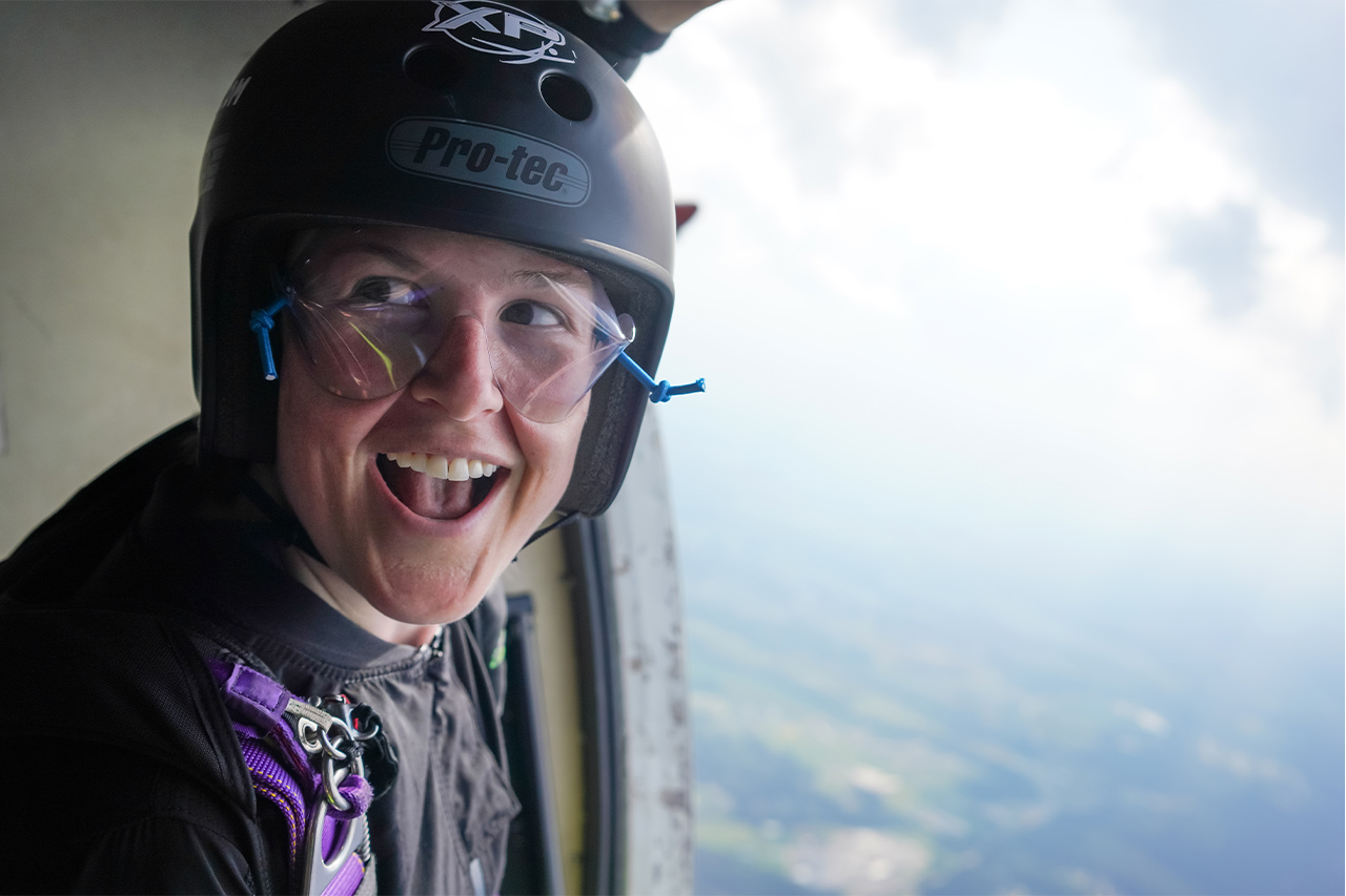 Skydiving student smiling for the camera while in the door of an airplane