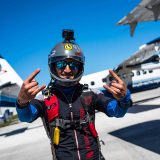 Licensed skydiver preparing to board aircraft giving rock on sign with hands